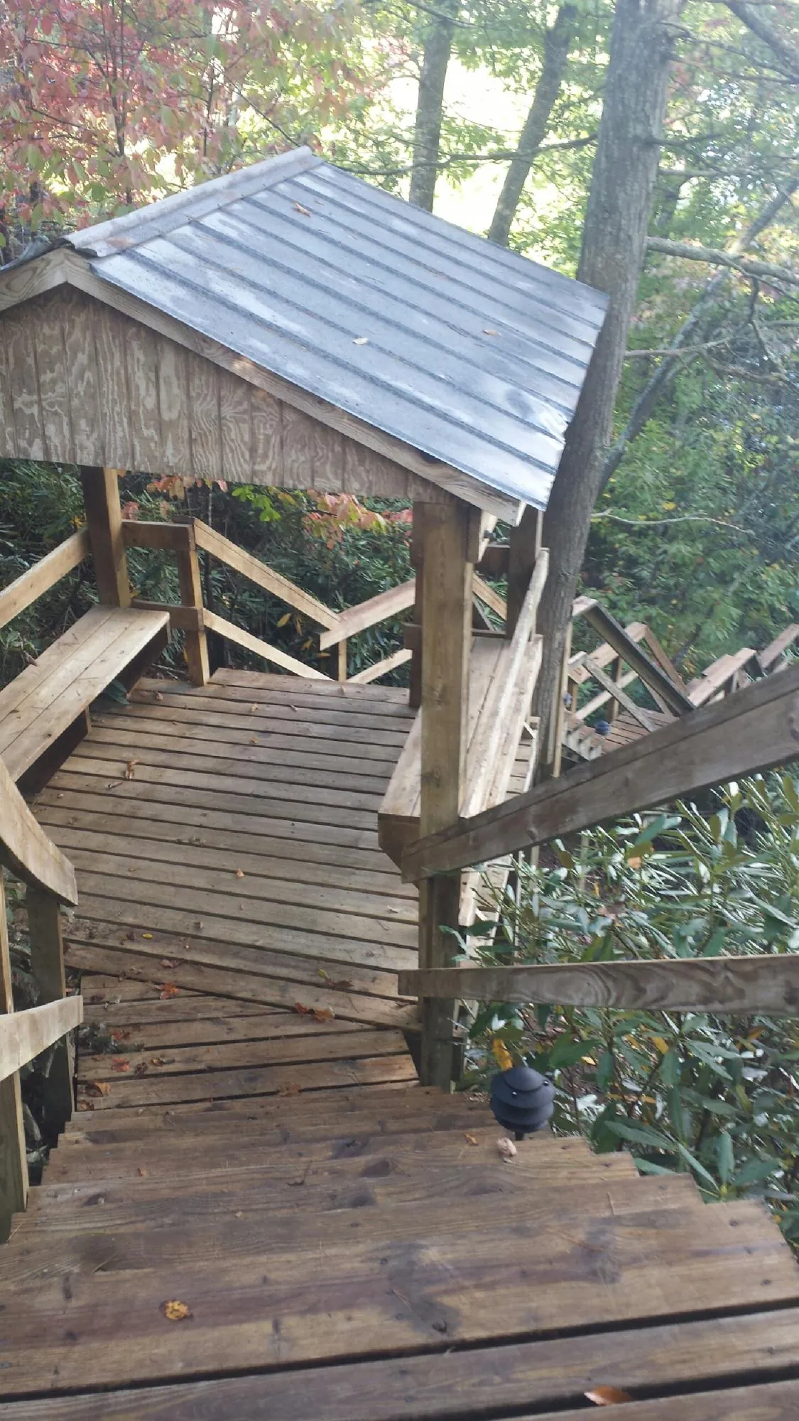 Metal roofed shelter over wooden steps on a wooded walkway — Skylight Repair & Installation work by our crew in Vineland